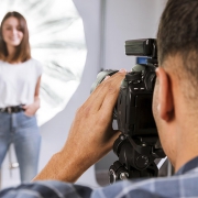 Photographer-taking-a-photo-of-a-woman-model-in-studio